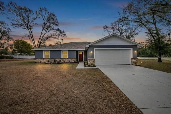 a front view of a house with a yard and trees