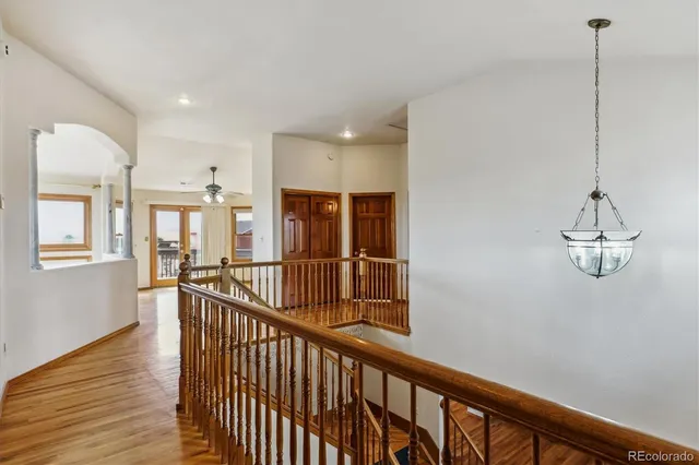 a view of a hallway with wooden floor and windows