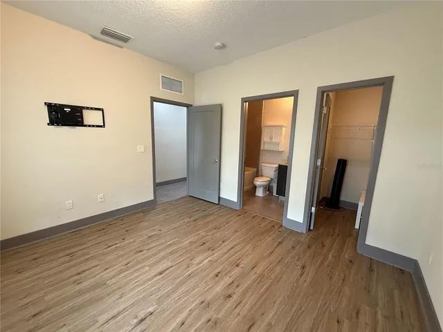 a view of a hallway with wooden floor and closet