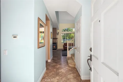 a hallway with a view of bedroom with wooden floor