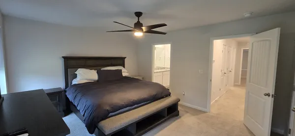 a bedroom with a bed and a ceiling fan