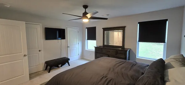 a bedroom with a bed and a flat tv screen on the dresser
