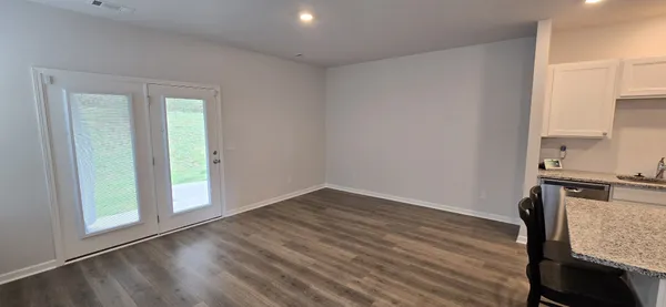 an empty room with wooden floor a sink and a window