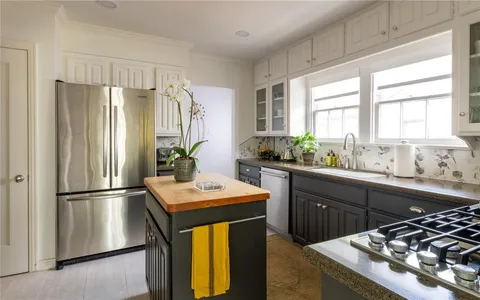 a kitchen with stainless steel appliances kitchen island granite countertop a refrigerator and a sink