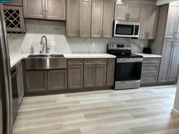 a kitchen with stainless steel appliances granite countertop a sink stove and refrigerator