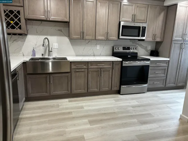 a kitchen with stainless steel appliances granite countertop a sink stove and refrigerator