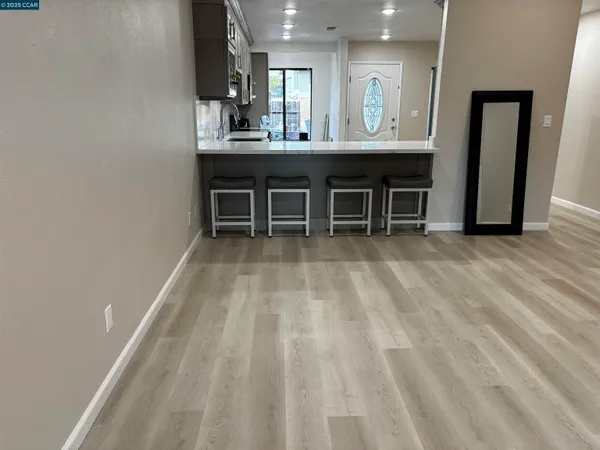 a living room with stainless steel appliances furniture a sink and a view of kitchen