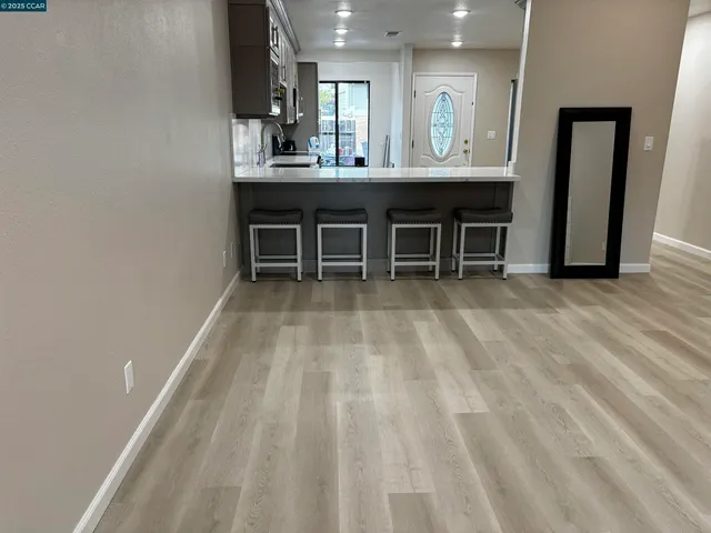 a living room with stainless steel appliances furniture a sink and a view of kitchen