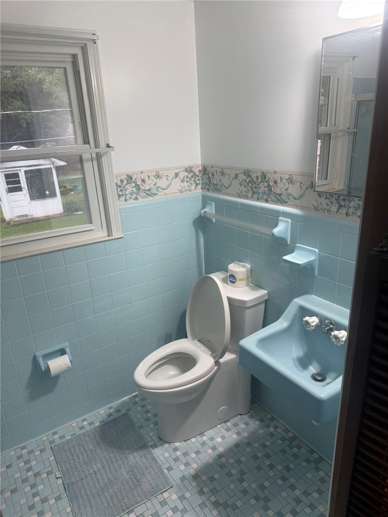 4027 Belhaven Road Belton, SC 29627 - Photo 12 of 24 A well-lit bathroom showcases its patterned tiled floor and light blue wall tiling.