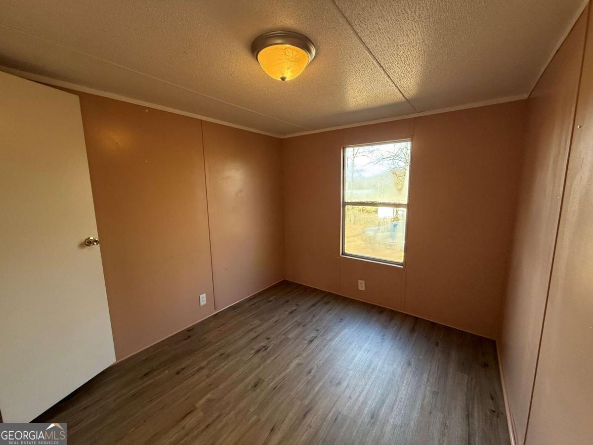 129 Elza Drive Cleveland, GA 30528 - Photo 11 of 14 a view of an empty room with wooden floor and a window