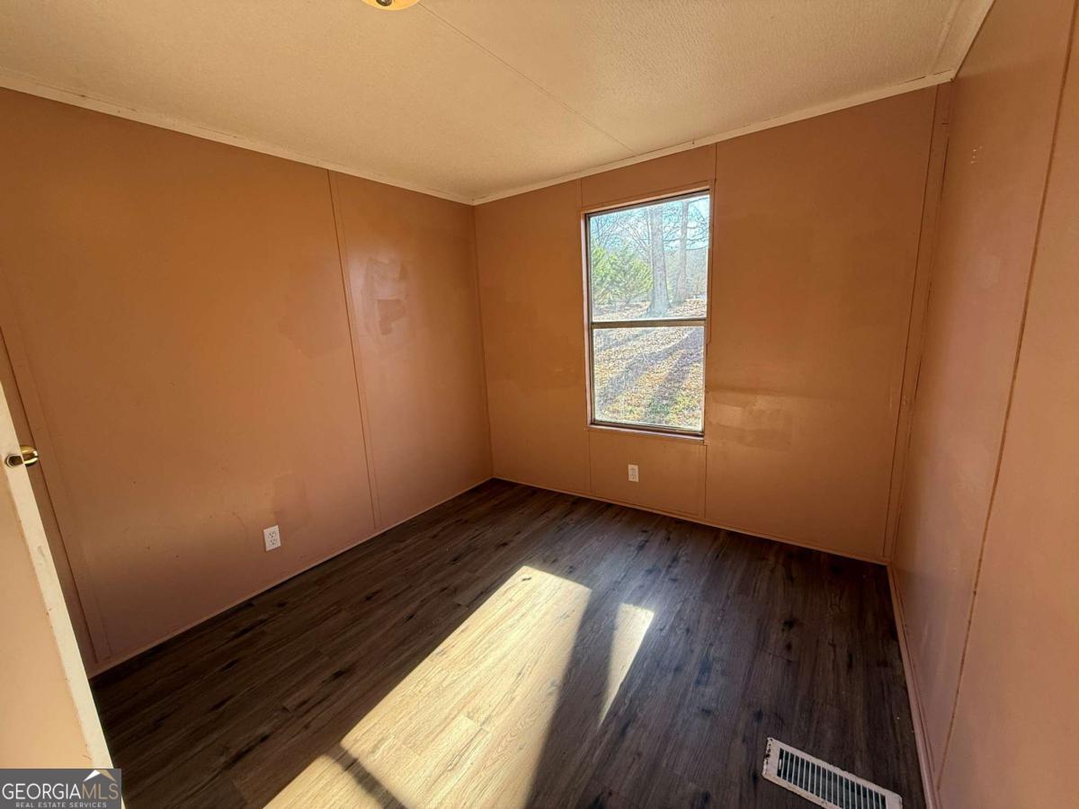 129 Elza Drive Cleveland, GA 30528 - Photo 9 of 14 a view of an empty room with wooden floor and a window