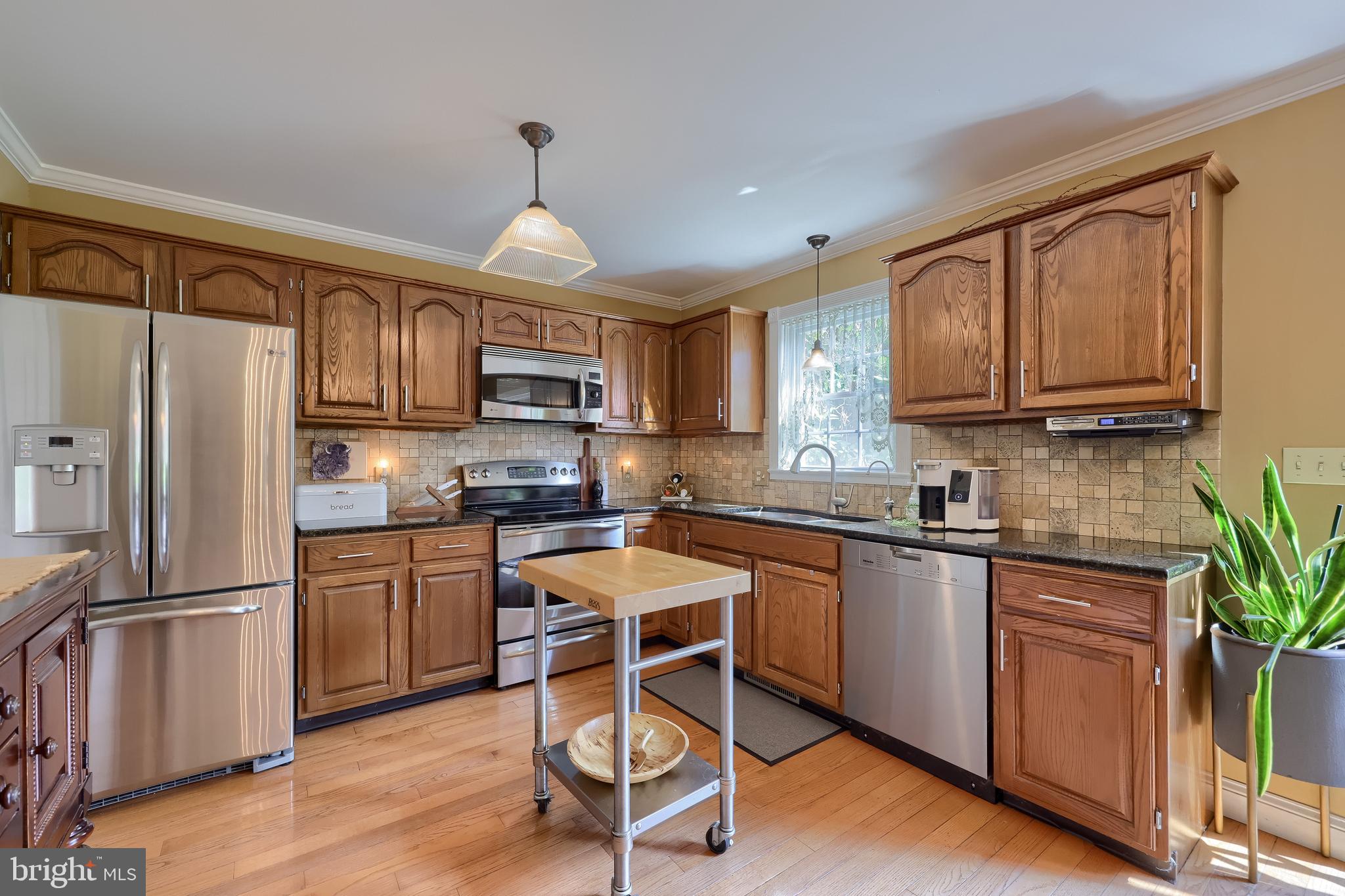 15 Sunrise Drive Lititz, PA 17543 - Photo 14 of 35 a kitchen with granite countertop wooden floors white cabinets and stainless steel appliances