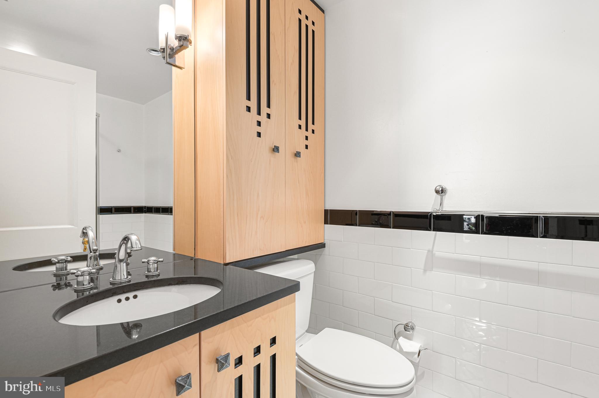 3908 North Charles Street, Unit 501 Baltimore, MD 21218 - Photo 41 of 54 a bathroom with a granite countertop sink and a mirror with toilet