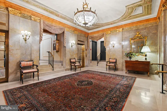 a living room with furniture a dining table and a chandelier