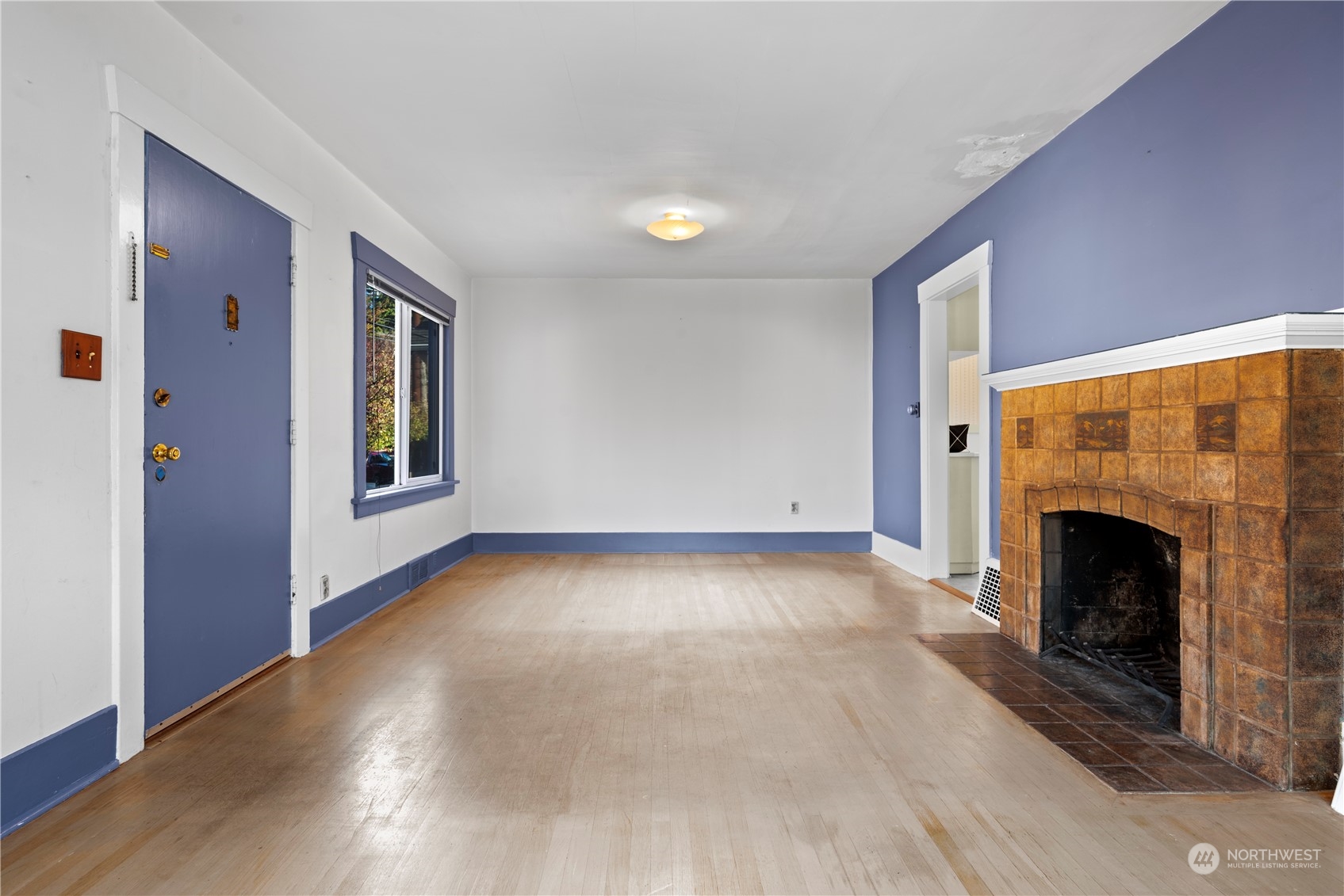 517 North 84th Street Seattle, WA 98103 - Photo 6 of 29 a view of empty room with fireplace and wooden floor