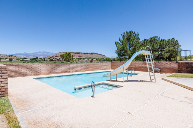 1470 Redwood Tree Street St. George, UT 84790 - Photo 49 of 53 Outdoor swimming pool with integrated spa and slide, surrounded by a concrete patio