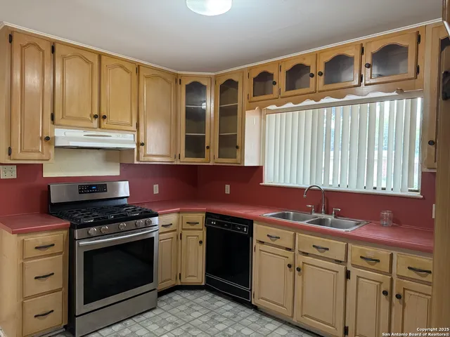 a kitchen with stainless steel appliances granite countertop a stove and a sink