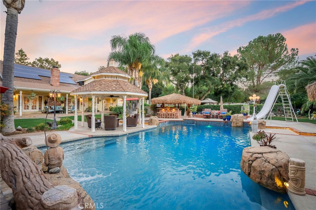 27767 Sand Canyon Road Canyon Country, CA 91387 - Photo 13 of 64 a view of a swimming pool with lawn chairs under an umbrella