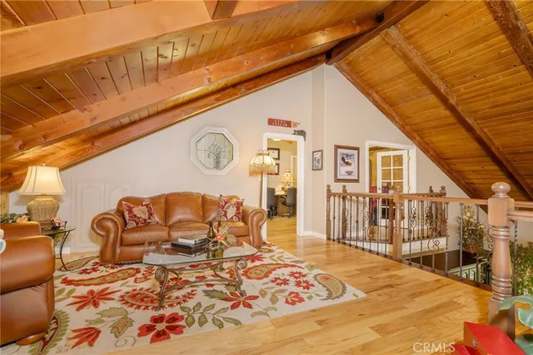 a spacious bedroom with a bed a dresser and a chandelier