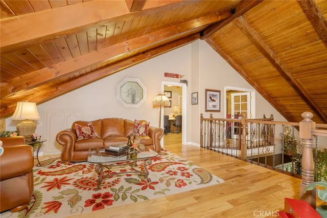 a spacious bedroom with a bed a dresser and a chandelier