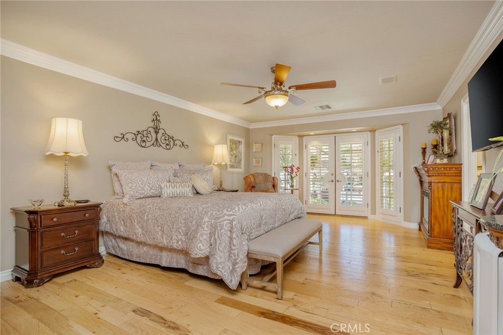 27767 Sand Canyon Road Canyon Country, CA 91387 - Photo 34 of 64 a spacious bedroom with a bed a dresser and a chandelier