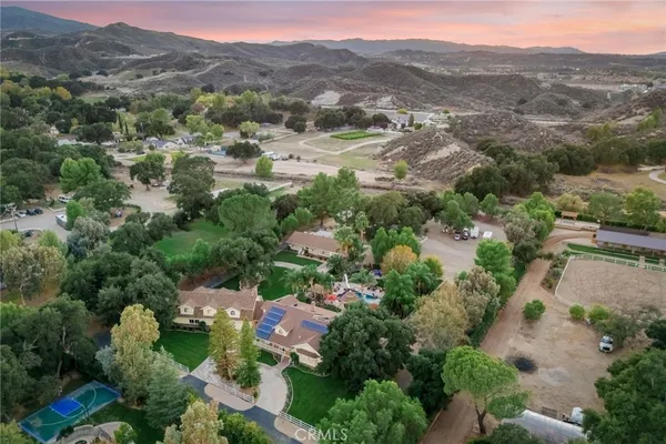 an aerial view of green landscape with trees houses and mountain view