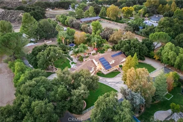 an aerial view of residential houses with outdoor space and trees