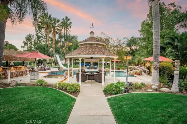 a view of a swimming pool with lawn chairs under an umbrella