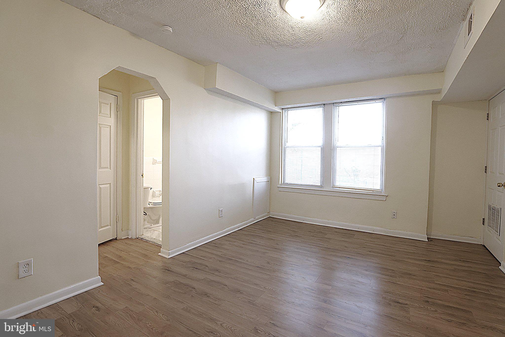 4329 Halley Terrace Southeast, Unit 3 Washington, DC 20032 - Photo 2 of 8 an empty room with wooden floor and windows
