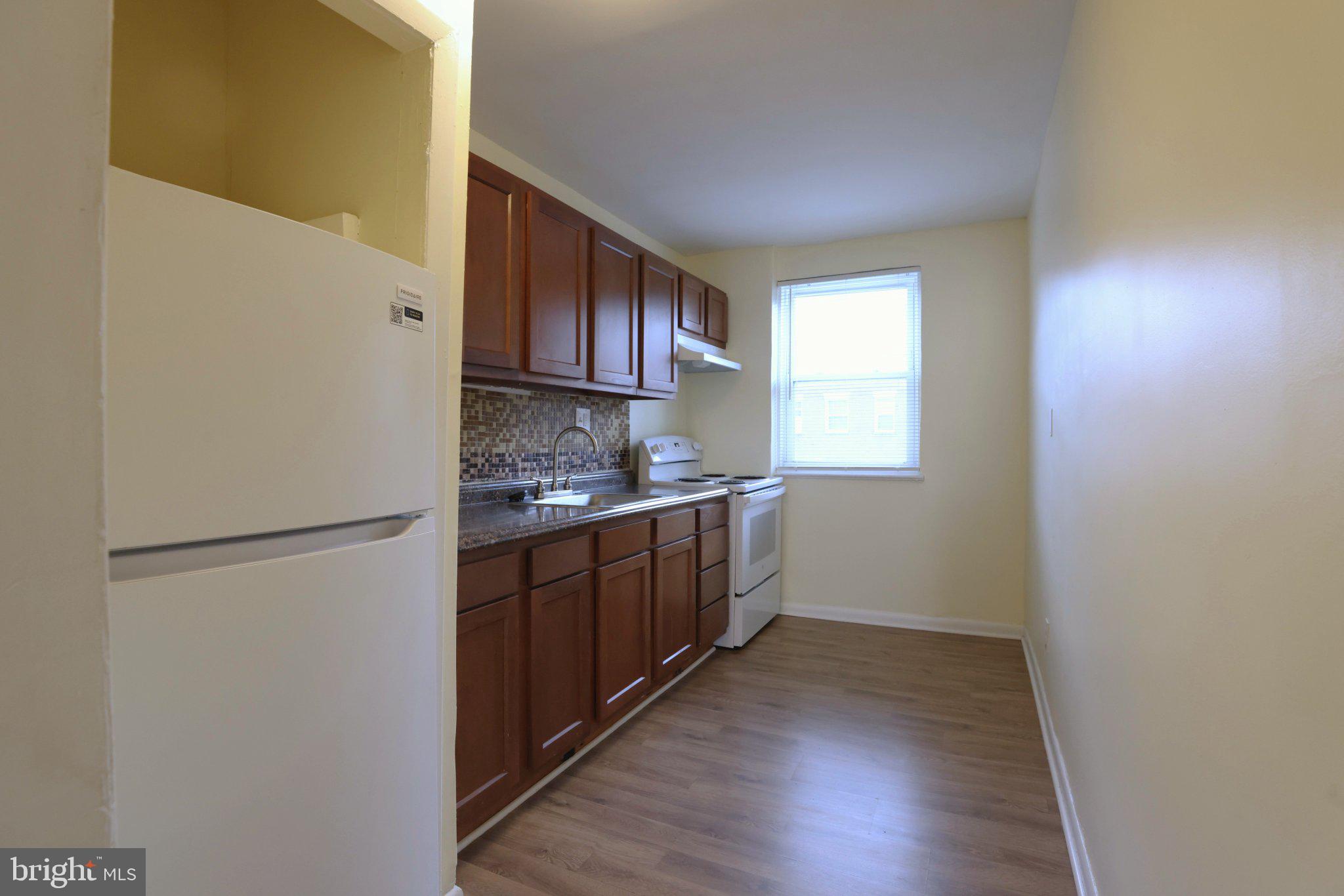 4329 Halley Terrace Southeast, Unit 3 Washington, DC 20032 - Photo 3 of 8 a kitchen with a refrigerator a stove a microwave and wooden floor