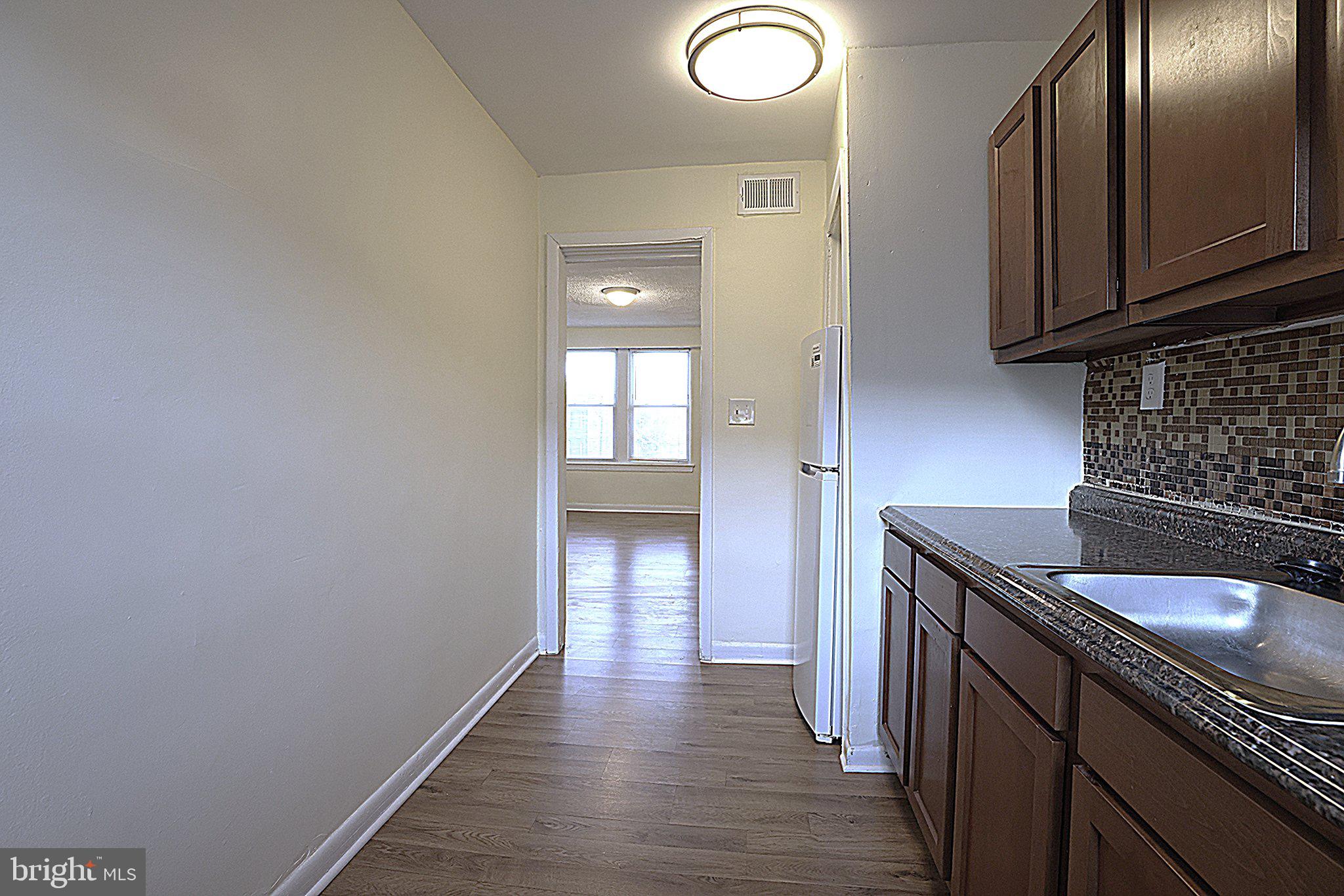 4329 Halley Terrace Southeast, Unit 3 Washington, DC 20032 - Photo 4 of 8 a kitchen with granite countertop a sink and cabinets
