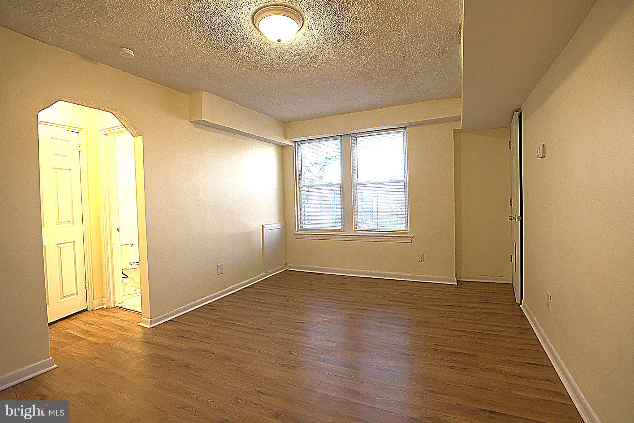 4329 Halley Terrace Southeast, Unit 3 Washington, DC 20032 - Photo 5 of 8 a view of an empty room with wooden floor and a window