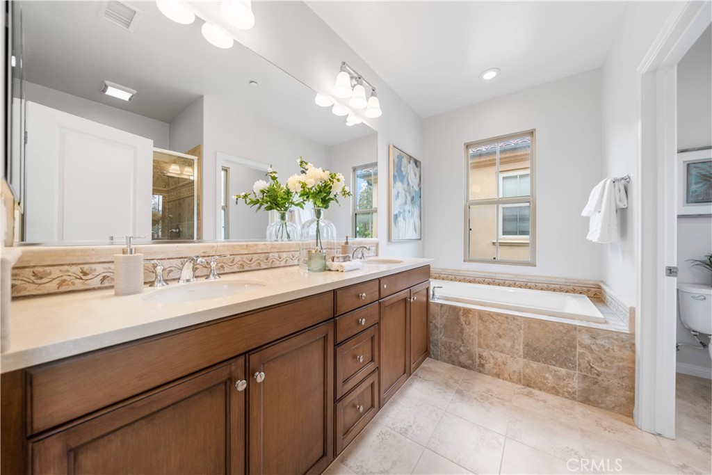 33 Jonquil Irvine, CA 92618 - Photo 31 of 48 a spacious bathroom with a granite countertop double vanity sink a large mirror a bathtub and next to a window