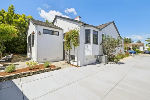 a view of backyard with outdoor seating and wooden fence