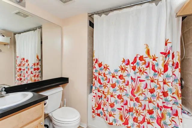 a bathroom with a toilet and a shower curtain