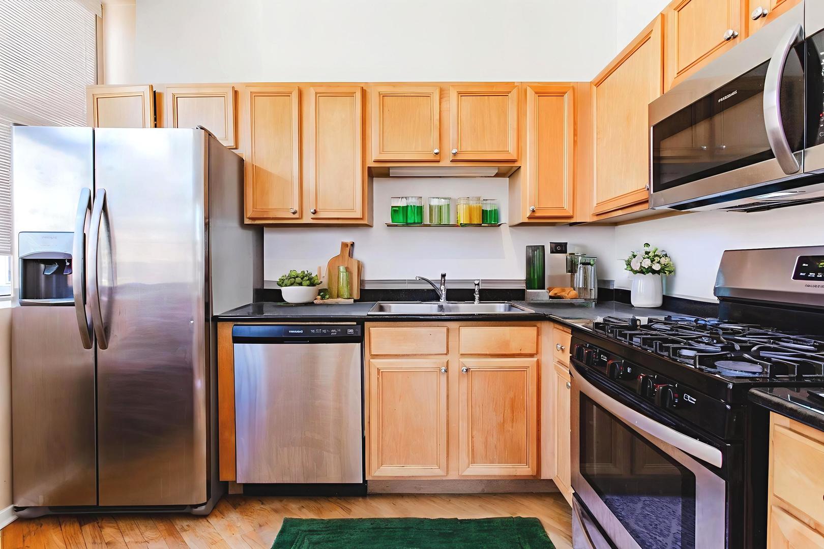 500 South Clinton Street, Unit 743 Chicago, IL 60607 - Photo 4 of 16 a kitchen with stainless steel appliances granite countertop a refrigerator sink and stove