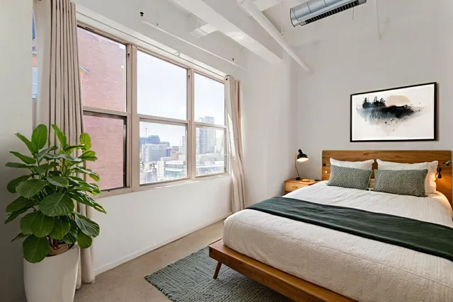 a bedroom with a bed and a potted plant