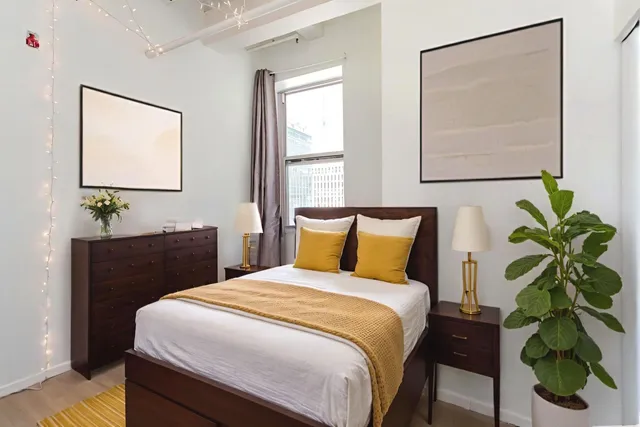 a bedroom with a bed and a potted plant