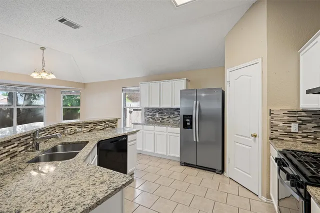 a kitchen with stainless steel appliances granite countertop a stove a sink and a refrigerator