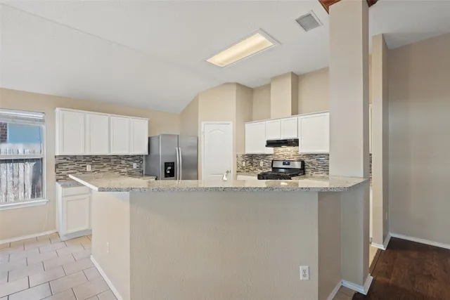 a kitchen with stainless steel appliances a stove refrigerator sink and cabinets