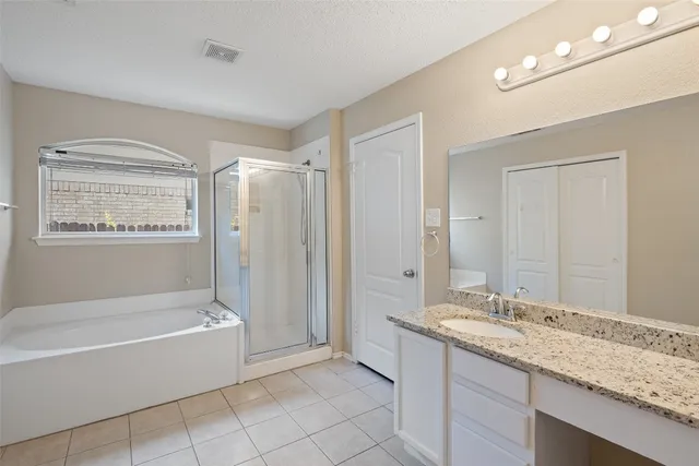 a bathroom with a granite countertop sink a mirror and a bathtub