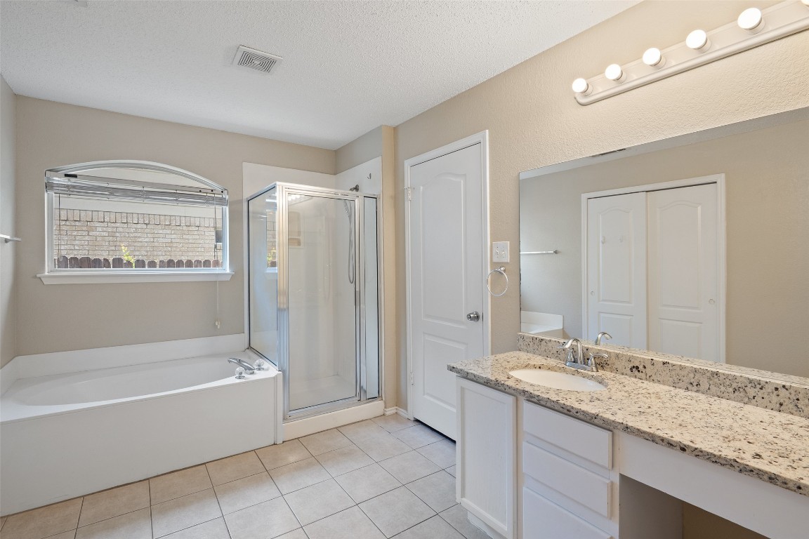 1008 Chippewa Round Rock, TX 78665 - Photo 22 of 36 a bathroom with a granite countertop sink a mirror and a bathtub