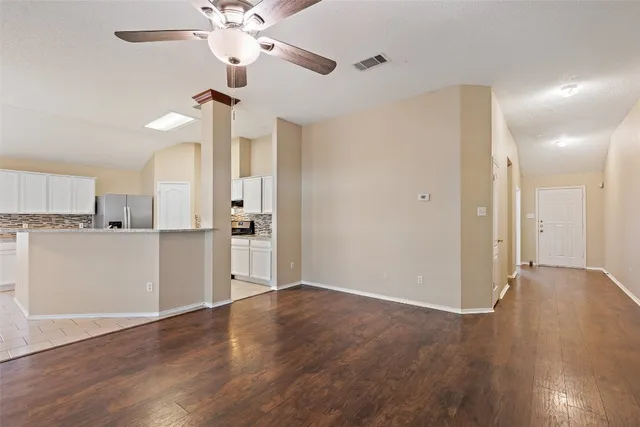 a view of a kitchen with wooden floor and a ceiling fan
