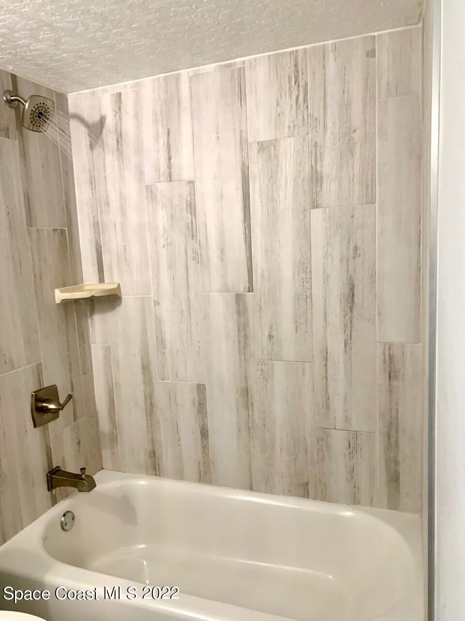 584 North Wickham Road, Unit 82 Melbourne, FL 32935 - Photo 12 of 43 a bathroom with a shower curtain and a sink