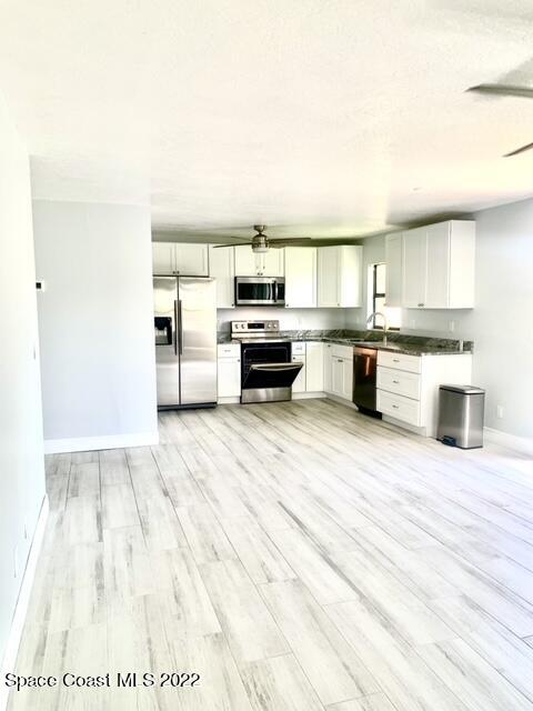 584 North Wickham Road, Unit 82 Melbourne, FL 32935 - Photo 30 of 43 a kitchen with stainless steel appliances wooden floor and view living room