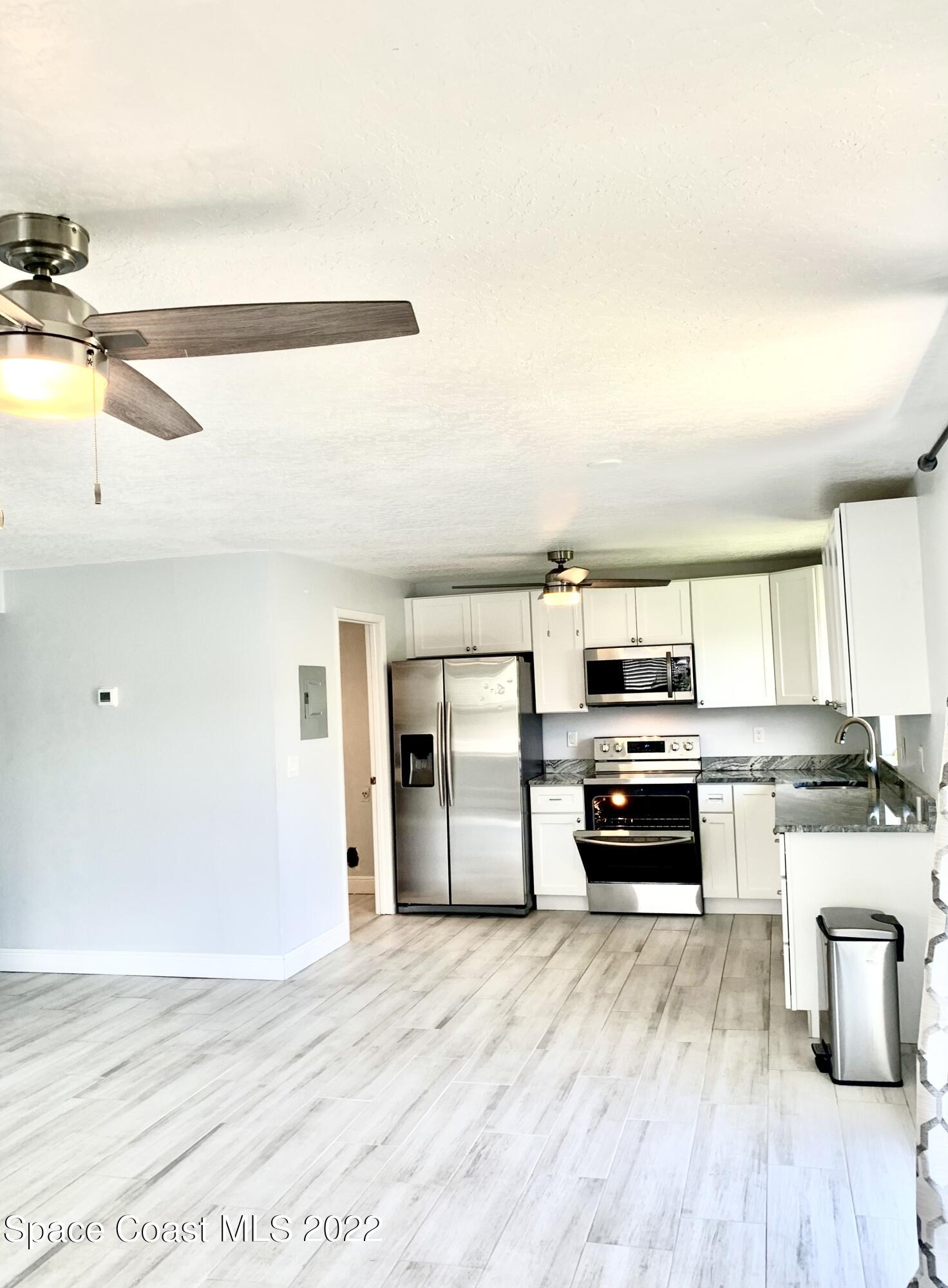 584 North Wickham Road, Unit 82 Melbourne, FL 32935 - Photo 31 of 43 a kitchen with a stove and a refrigerator