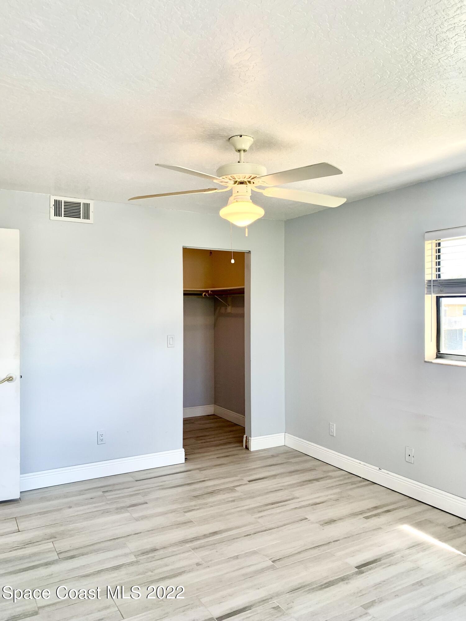 584 North Wickham Road, Unit 82 Melbourne, FL 32935 - Photo 37 of 43 a view of a livingroom with wooden floor and a ceiling fan