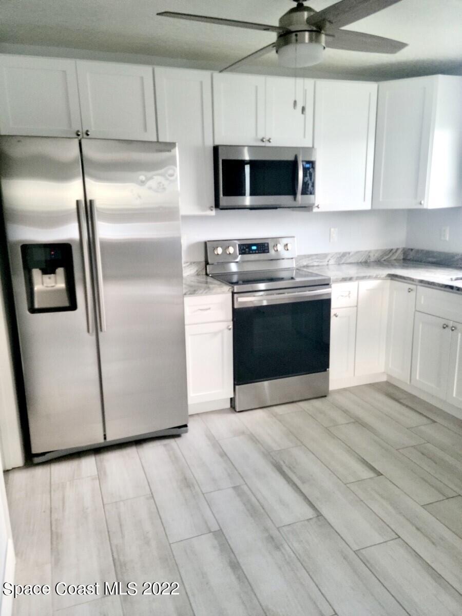 584 North Wickham Road, Unit 82 Melbourne, FL 32935 - Photo 42 of 43 a kitchen with stainless steel appliances a stove a microwave and a sink