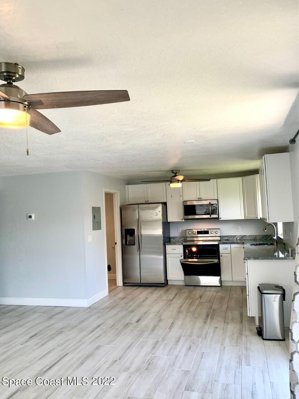 584 North Wickham Road, Unit 82 Melbourne, FL 32935 - Photo 5 of 43 a kitchen with stainless steel appliances a stove a refrigerator and a sink