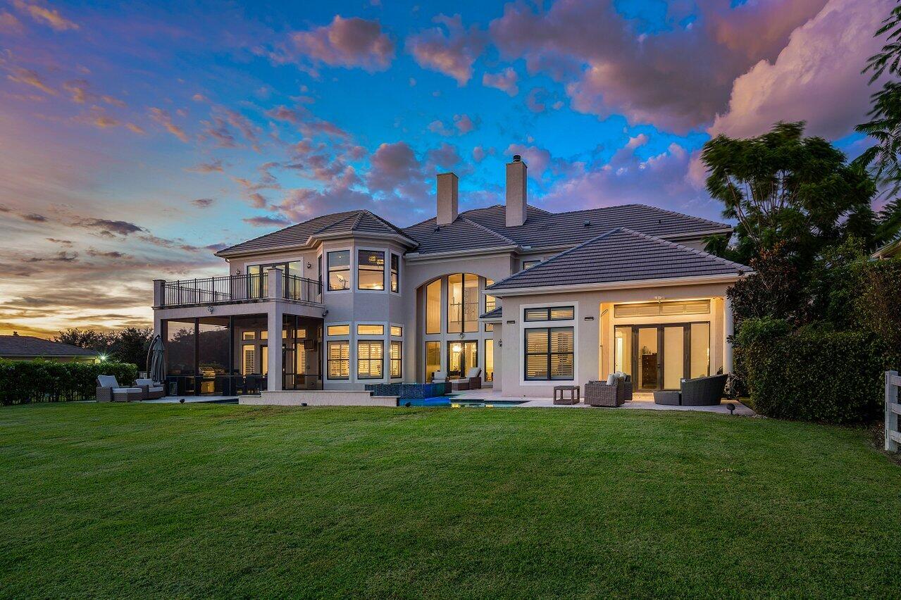 a front view of a house with a big yard and potted plants